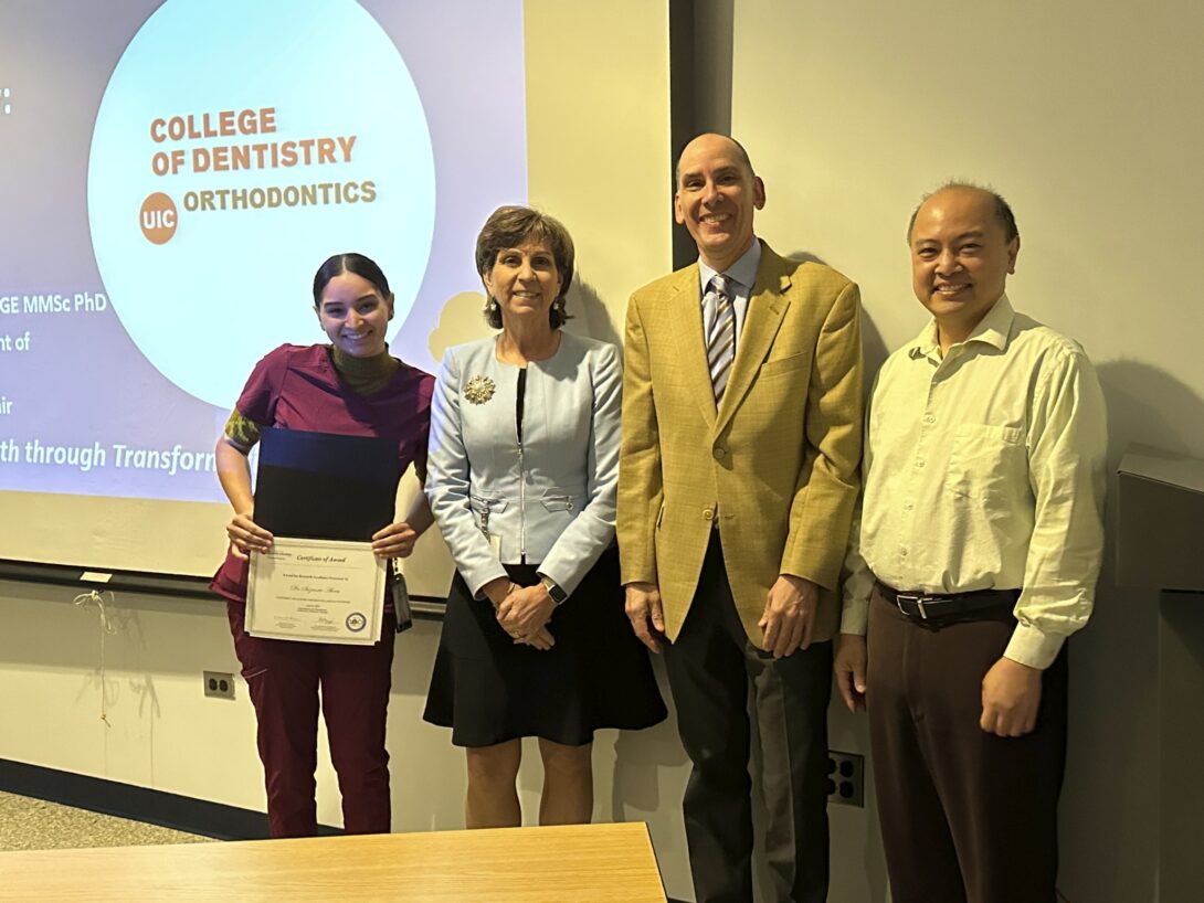Dr. Suzanne Abreu receives an AAOF RAA grant certificate while standing with Dean Susan Rowan, Dr. Peter Durbin and Dr. Budi Kusnoto, all smiling.